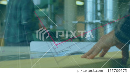 Leaning business casual colleagues in office examining blueprints, pink grid lines overlaying plans 135709675