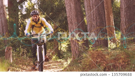 Cyclist wearing helmet, yellow jacket riding mountain bike on pine trail, with digital overlay Cyclist wearing helmet, yellow jacket riding mountain bike on pine trail, with digital overlay 135709688