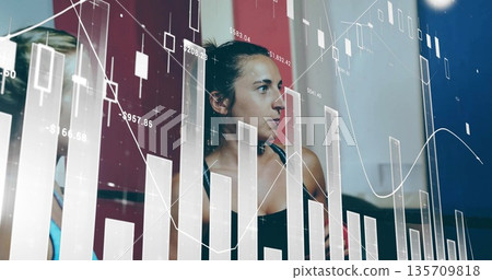 Analyzing workout partners in sports tops monitoring training metrics in gym, with data overlays 135709818