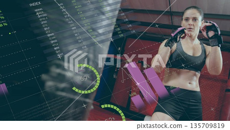 Punching heavy bag at MMA gym wearing fingerless gloves, with digital overlays, copy space Punching heavy bag at MMA gym wearing fingerless gloves, with digital overlays, copy space 135709819