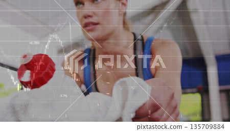 Gripping towel-wrapped rowing machine handle with red knob woman wearing blue workout top in gym Gripping towel-wrapped rowing machine handle with red knob woman wearing blue workout top in gym 135709884