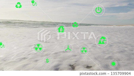 Floating green icons drifting above sandy beach, showcasing recycling and wind turbine concepts Floating green icons drifting above sandy beach, showcasing recycling and wind turbine concepts 135709904