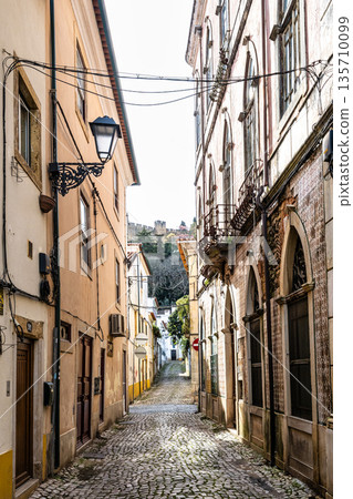 Narrow street with old buildings in the old town Tomar in Portugal. Narrow street with old buildings in the old town Tomar in Portugal. 135710099