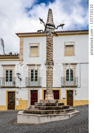 Pelourinho of Elvas in Portugal, a historic stone pillory on a pedestal, with medieval houses in the background. Pelourinho of Elvas in Portugal, a historic stone pillory on a pedestal, with medieval houses in the background. 135710110