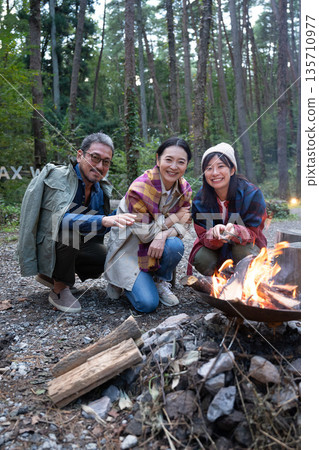 Friends enjoying a bonfire at camp Friends enjoying a bonfire at camp 135710977