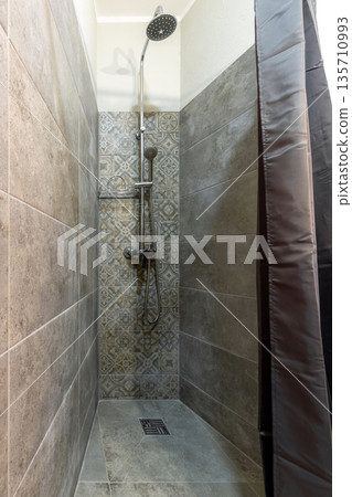 Corner walk-in shower with grey stone tiles and patterned accent wall Corner walk-in shower with grey stone tiles and patterned accent wall 135710993