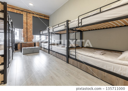 Industrial style hostel dormitory with black bunk beds and brick wall 135711000