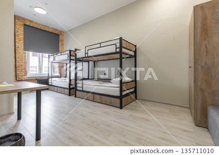 Hostel dormitory room with black bunk beds and exposed brick wall Hostel dormitory room with black bunk beds and exposed brick wall 135711010