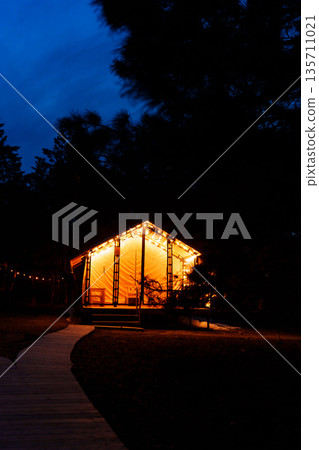 Glamping from tent houses in the forest in the dark. Glamping from tent houses in the forest in the dark. 135711021