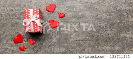 Valentine day composition: red gift box with bow and heart. Christmas present. View from above. Space for text. Holday greeting card 135711335