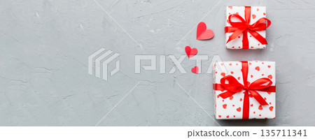 Valentine day composition: red gift box with bow and heart. Christmas present. View from above. Space for text. Holday greeting card 135711341