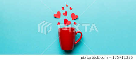 red cup on colored background, splashes of red little hearts, top view with copy space 135711356