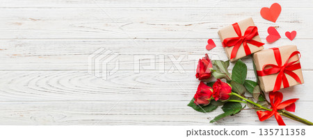 Valentine's day composition with rose flower, red heart and gift boxes on table. mother day and birthday greeting, copy space, top view 135711358