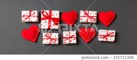 Top view colorful valentine background made of gift boxes and red textile hearts. Valentine's Day concept with copy space Top view colorful valentine background made of gift boxes and red textile hearts. Valentine's Day concept with copy space 135711386
