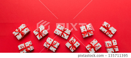 Valentine day composition: red gift box with bow and heart. Christmas present. View from above. Space for text. Holday greeting card Valentine day composition: red gift box with bow and heart. Christmas present. View from above. Space for text. Holday greeting card 135711395