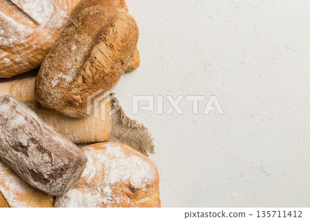 Homemade natural breads. Different kinds of fresh bread as background, top view with copy space Homemade natural breads. Different kinds of fresh bread as background, top view with copy space 135711412