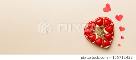 Delicious chocolate pralines in red box for Valentine's Day. Heart shaped box of chocolates top view with copy space Delicious chocolate pralines in red box for Valentine's Day. Heart shaped box of chocolates top view with copy space 135711422
