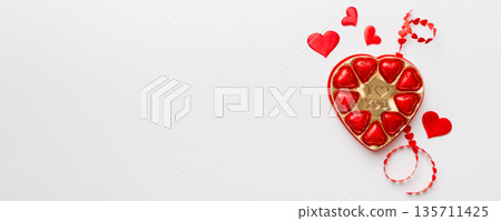 Delicious chocolate pralines in red box for Valentine's Day. Heart shaped box of chocolates top view with copy space Delicious chocolate pralines in red box for Valentine's Day. Heart shaped box of chocolates top view with copy space 135711425