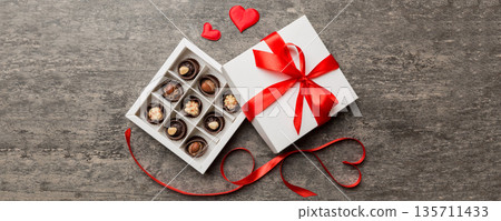 Delicious chocolate pralines in red box for Valentine's Day. Heart shaped box of chocolates top view with copy space Delicious chocolate pralines in red box for Valentine's Day. Heart shaped box of chocolates top view with copy space 135711433