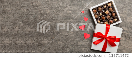 Delicious chocolate pralines in red box for Valentine's Day. Heart shaped box of chocolates top view with copy space Delicious chocolate pralines in red box for Valentine's Day. Heart shaped box of chocolates top view with copy space 135711472