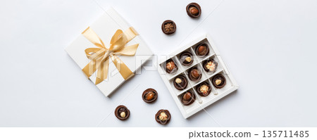 White box with chocolates candies and golden tape. top view with copy space White box with chocolates candies and golden tape. top view with copy space 135711485