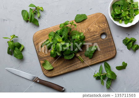 Fresh mint on Cutting board table, top view. Flat lay Space for text Fresh mint on Cutting board table, top view. Flat lay Space for text 135711503