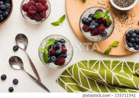 Healthy breakfast or morning with chia seeds vanilla pudding raspberry and blueberry berries on table background, vegetarian food, diet and health concept. Chia pudding with raspberry and blueberry Healthy breakfast or morning with chia seeds vanilla pudding raspberry and blueberry berries on table background, vegetarian food, diet and health concept. Chia pudding with raspberry and blueberry 135711542