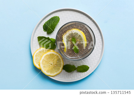 Healthy breakfast or morning with chia seeds lemon and mint on table background, vegetarian food, diet and health concept. Chia pudding with lemon and mint Healthy breakfast or morning with chia seeds lemon and mint on table background, vegetarian food, diet and health concept. Chia pudding with lemon and mint 135711545