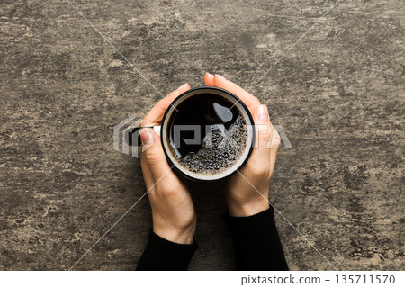Minimalistic style woman hand holding a cup of coffee on Colored background. Flat lay, top view cappuccino cup. Empty place for text, copy space. Coffee addiction. Top view, flat lay Minimalistic style woman hand holding a cup of coffee on Colored background. Flat lay, top view cappuccino cup. Empty place for text, copy space. Coffee addiction. Top view, flat lay 135711570