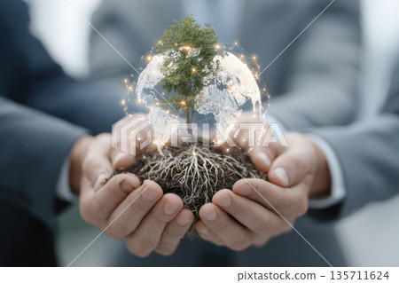 A group of people's hands in business suit holding a small tree together 135711624