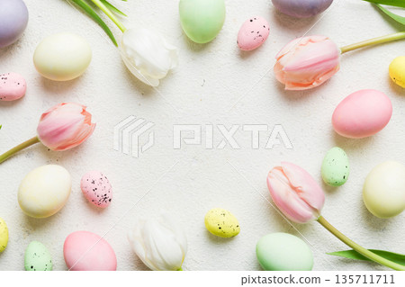 Happy Easter composition. Easter eggs on colored table with yellow Tulips. Natural dyed colorful eggs background top view with copy space Happy Easter composition. Easter eggs on colored table with yellow Tulips. Natural dyed colorful eggs background top view with copy space 135711711