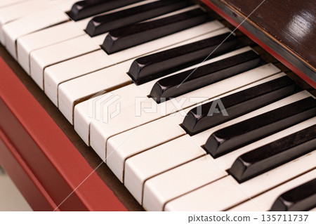 Close up of piano keyboard with black and white keys, classic musical instrument detail Close up of piano keyboard with black and white keys, classic musical instrument detail 135711737