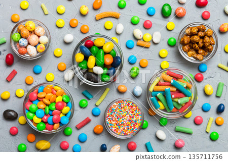 different colored round candy in bowl and jars. Top view of large variety sweets and candies with copy space 135711756