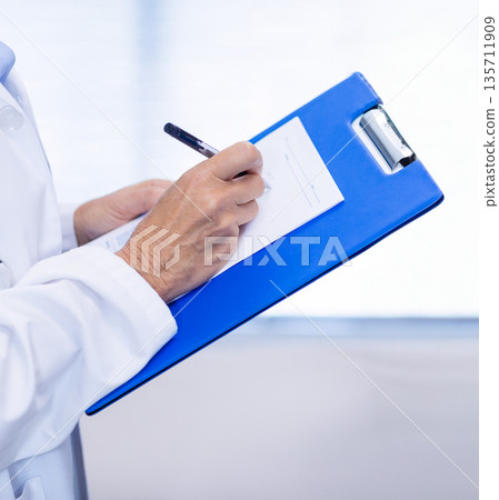 Medical worker wearing white coat with stethoscope holding clipboard filling form with pen, blinds Medical worker wearing white coat with stethoscope holding clipboard filling form with pen, blinds 135711909