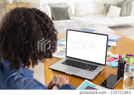 African American woman sketching color swatches on home office table with laptop, copy space 135711943