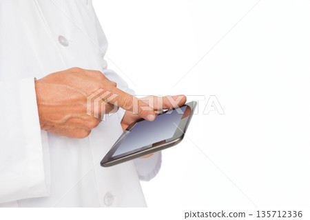 Hands wearing white lab coat tapping touchscreen tablet on plain white background, copy space 135712336
