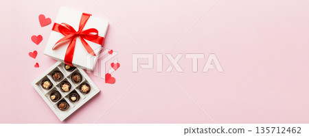 Delicious chocolate pralines in red box for Valentine's Day. Heart shaped box of chocolates top view with copy space 135712462