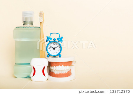 Mouthwash and other oral hygiene products on colored table top view with copy space. Flat lay. Dental hygiene. Oral care kit. Dentist concept Mouthwash and other oral hygiene products on colored table top view with copy space. Flat lay. Dental hygiene. Oral care kit. Dentist concept 135712570