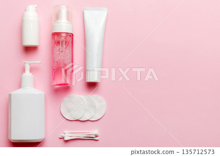 Micellar cleansing water and discs to remove cosmetics and cleanse the skin on colored background. Copy space top view Micellar cleansing water and discs to remove cosmetics and cleanse the skin on colored background. Copy space top view 135712573