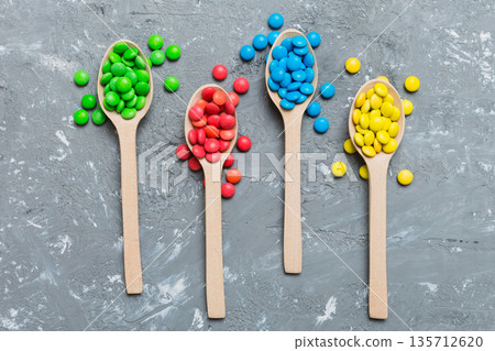 delicious colorful sweet candies on spoon on colored background . Confectionery decor top view with copy space delicious colorful sweet candies on spoon on colored background . Confectionery decor top view with copy space 135712620
