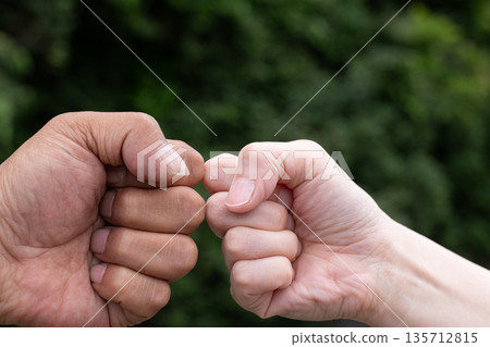 two people putting fists together two people putting fists together 135712815