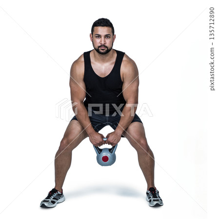 Muscular man lifting kettlebell, focusing on strength training and fitness 135712890