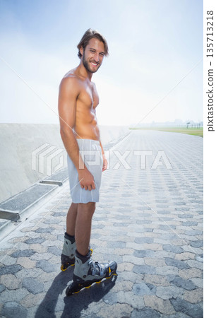 Man skating on hexagonal waterfront promenade wearing athletic shorts and inline skates Man skating on hexagonal waterfront promenade wearing athletic shorts and inline skates 135713218