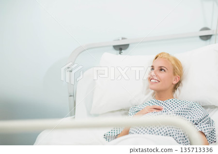 Female patient resting in hospital bed on pillow beside bed rail in hospital room, copy space Female patient resting in hospital bed on pillow beside bed rail in hospital room, copy space 135713336