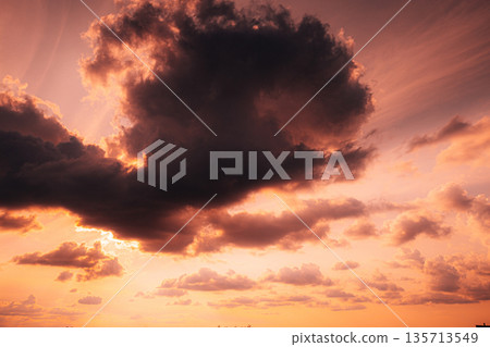 Sunset Cloudy Sky With Fluffy Clouds. Sunset Sky Natural Background. Sunrays In Dramatic Sky. Sunset In Yellow, Orange, Pink Colors 135713549