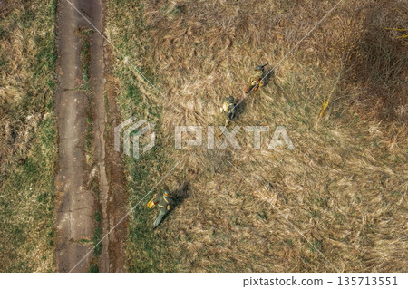 Men Dressed As US American Soldiers Of USA Infantry Of World War II sneaking around In spring Autumn Day. Soldiers prepare mortar for battle In dry grass. Aerial view elevated shot Men Dressed As US American Soldiers Of USA Infantry Of World War II sneaking around In spring Autumn Day. Soldiers prepare mortar for battle In dry grass. Aerial view elevated shot 135713551