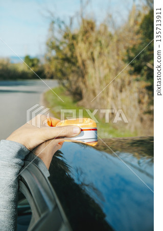 a man positioning a V16 warning beacon on a car 135713911