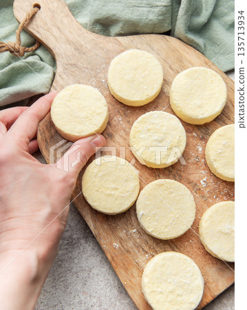 Hand preparing syrniki cottage cheese pancakes on wood 135713934