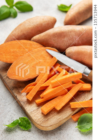 Sweet potato sticks with knife on wooden board 135713944