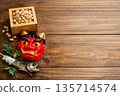 Setsubun beans, red demon mask, and holly sardines placed on a wooden background 135714574